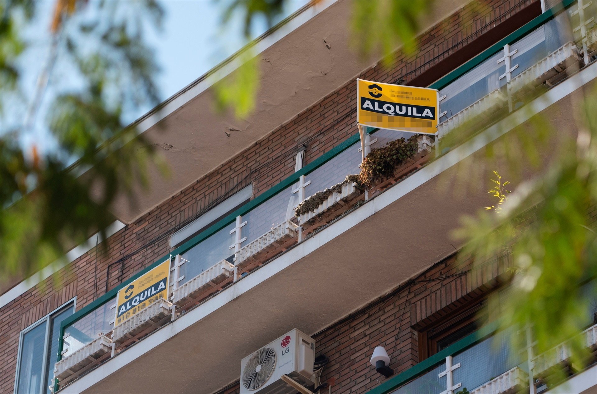 Un balcón de un piso en el que se anuncia el alquiler de la vivienda.