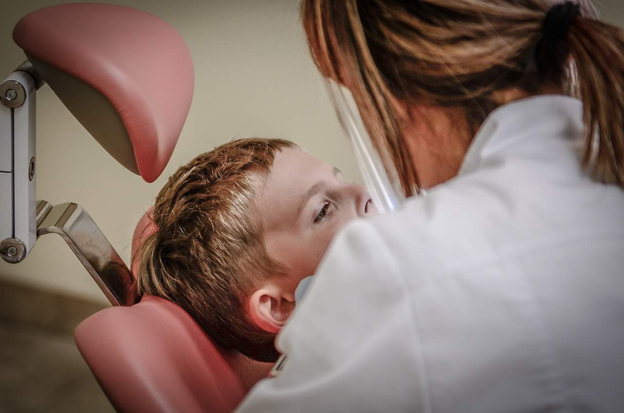 Una dentista haciendo una revisión a un niño. Michal Jarmoluk / Pixabay