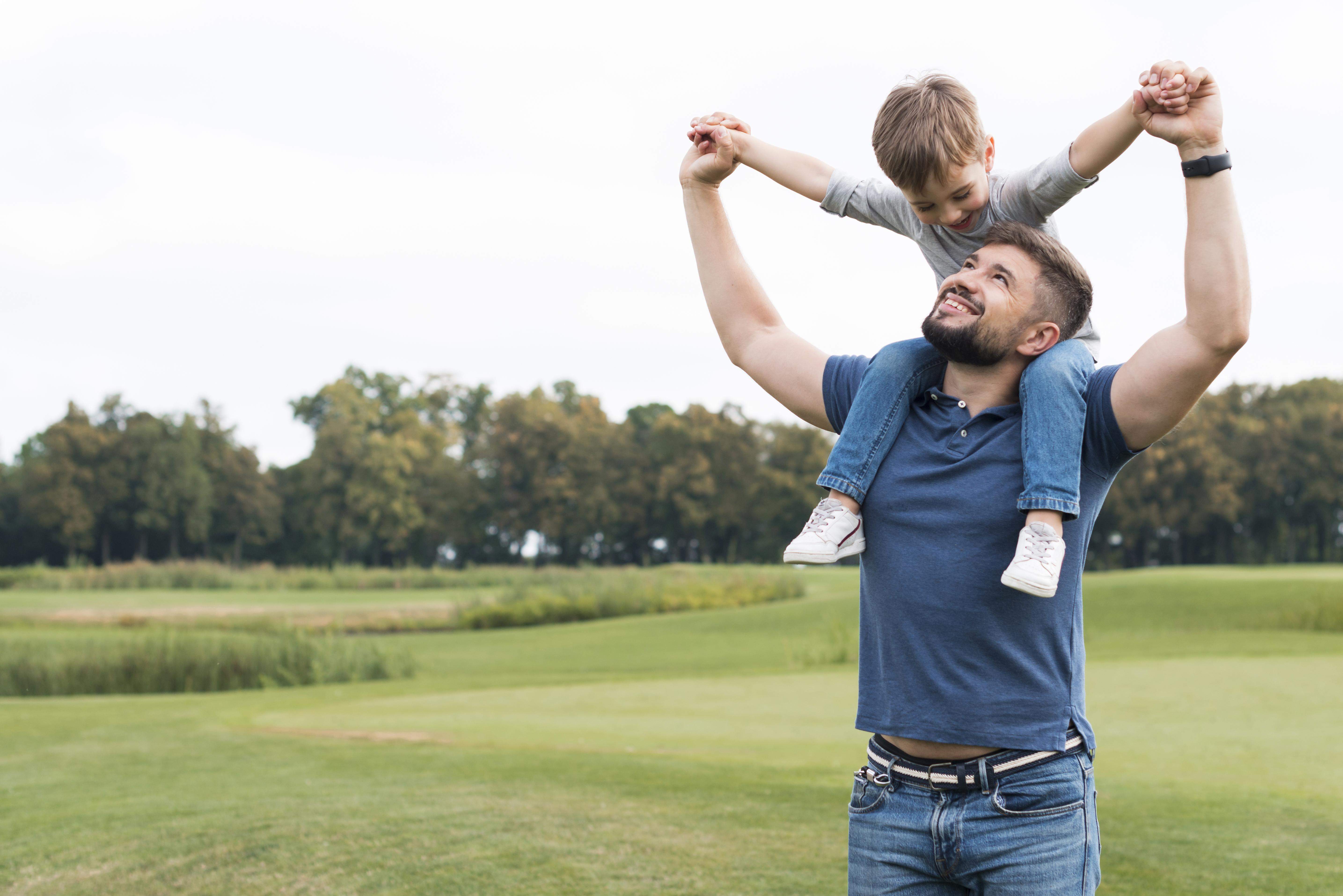 father holding his son his shoulders