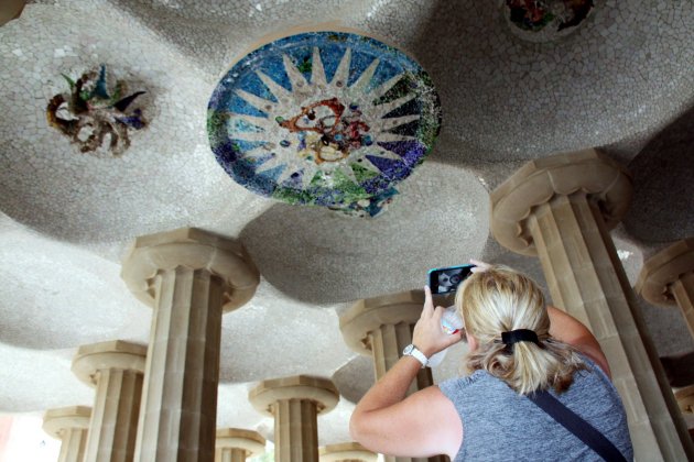 una turista fotografiant els medtallons de Parc Güell / ACN