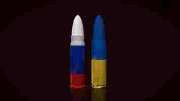 the ukraine and russia flag on bullets surface for business or war concept 3d rendering photo