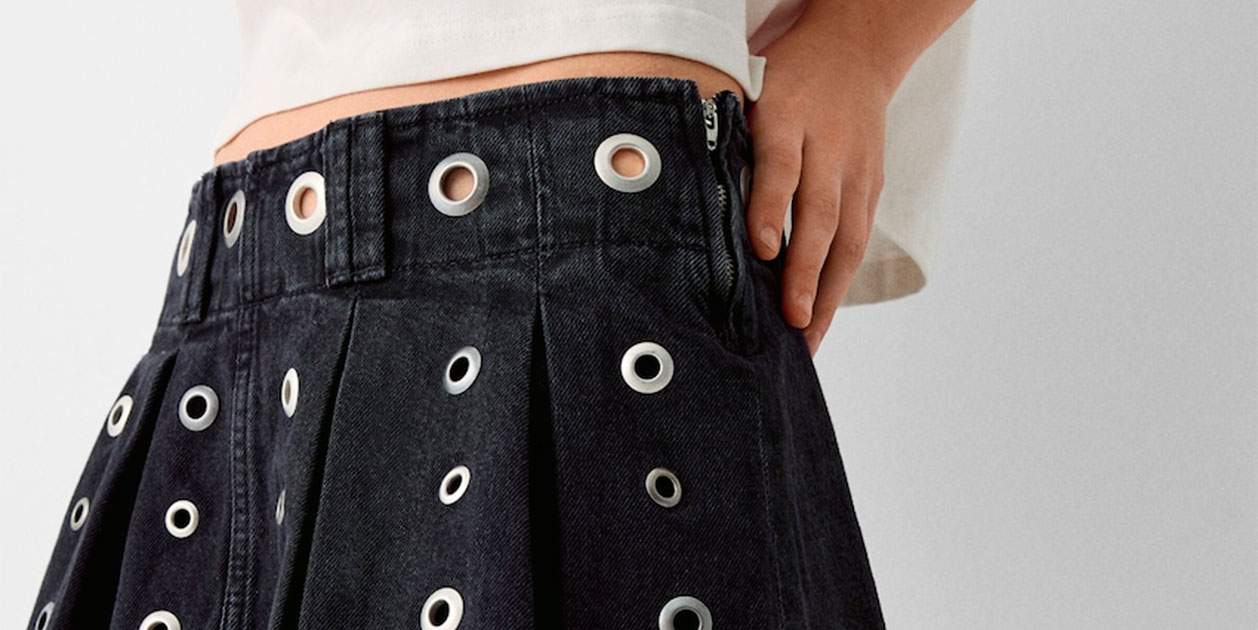 La famosa falda pantalón de tablas, ahora repleta de agujeros metálicos en Bershka