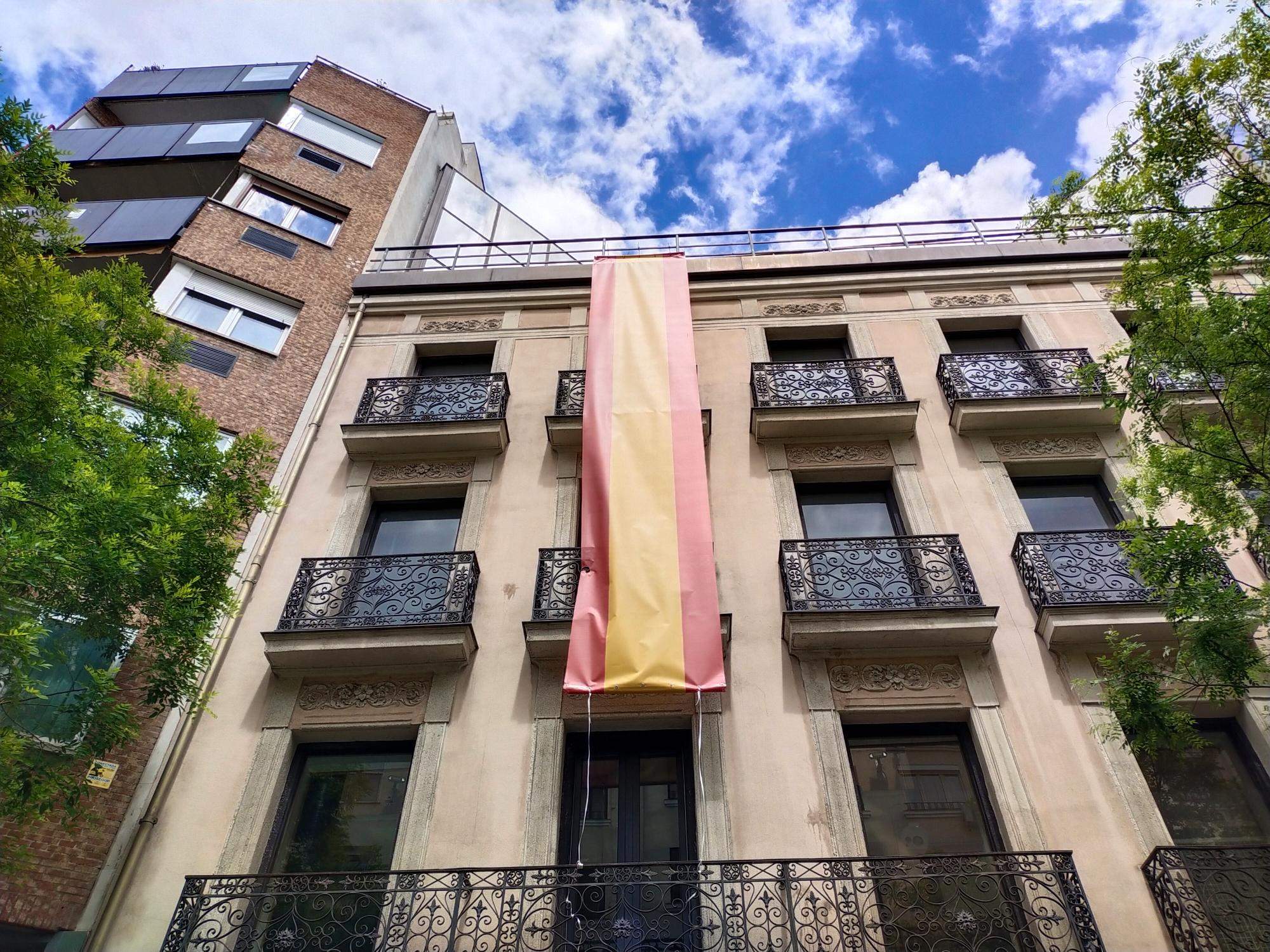Una gran bandera española viste la sede del PSOE en Madrid