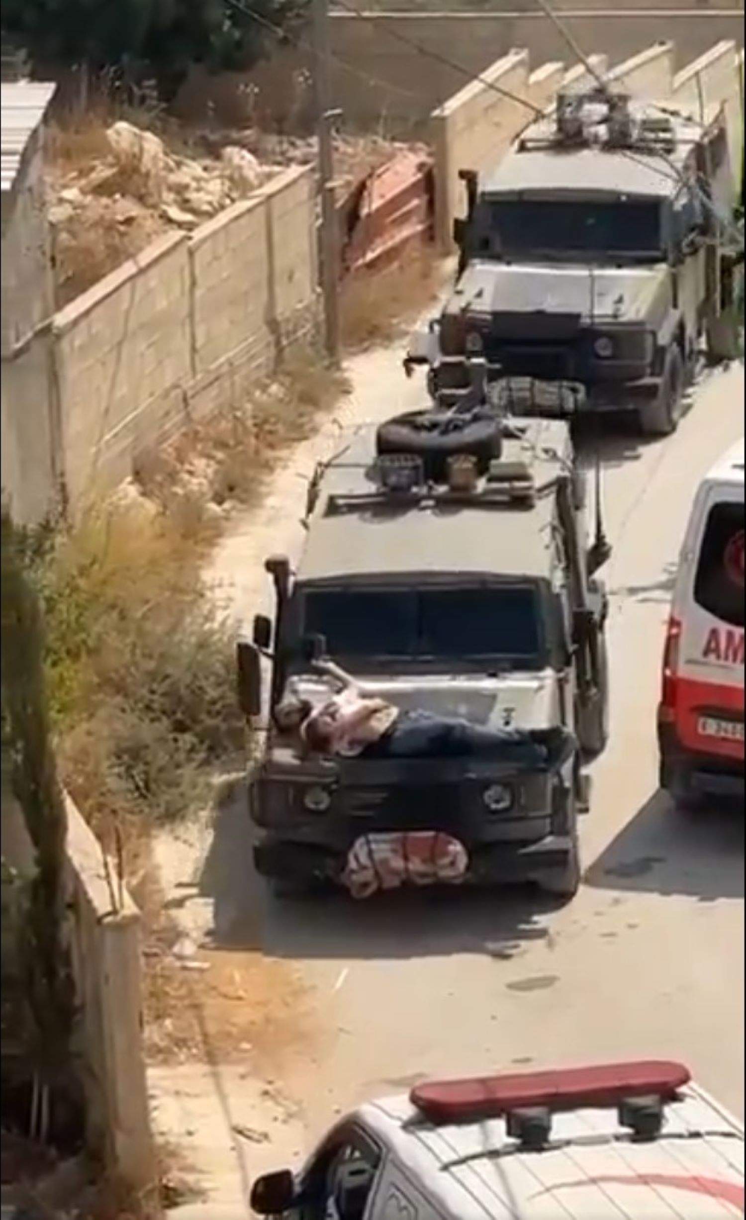 Soldados israelíes cuelgan a un hombre palestino herido en el capó de un jeep y lo pasean por Yenín