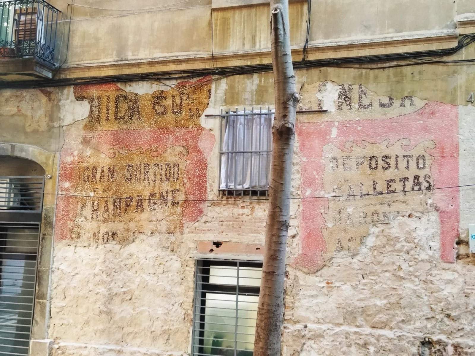 Campaña para proteger los antiguos letreros comerciales aparecidos en una fachada del Poble-sec