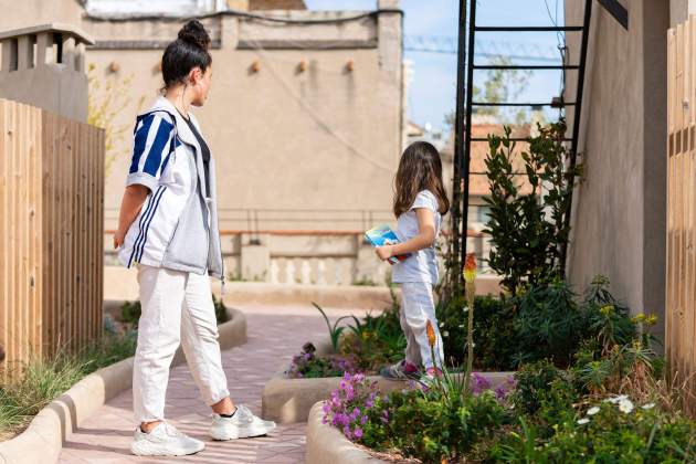 Una noia i una nena petita juguen coberta verda