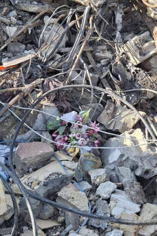 Unas flores de plastic entre los escombros del cementerio